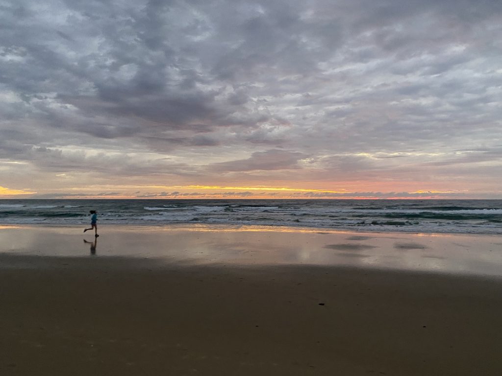 sunrise at the beach at Mooroochydore, sillouette of runner